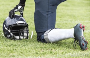 football-player-kneeling-with-helmet-off