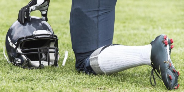 football-player-kneeling-with-helmet-off